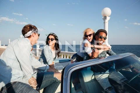 Multiethnic group of people talking and having fun in cabriolet Stock Photos
