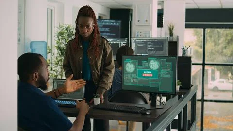 Multiethnic group of program coders dealing with hacked it system Stock Photos