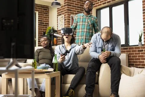 Multiethnic group react with frustration after female friend loses VR game Stock Photos