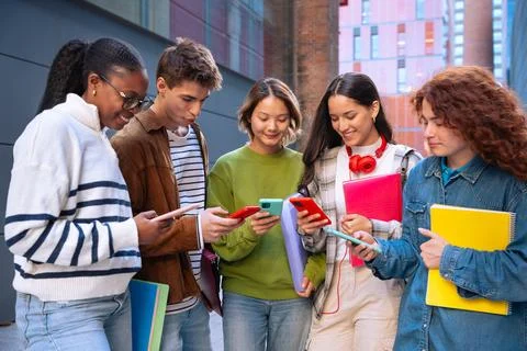 Multiethnic group of students browsing mobile phone apps outdoors. Stock-Fotos