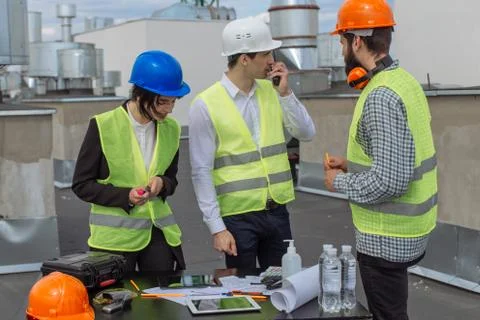 Multiethnic group of workers architect and two engineers have a conversation on Stock Photos