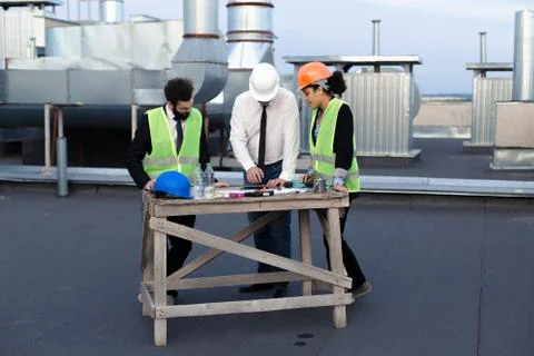 Multiethnic group of workers engineers architects foreman analyzing the plan of Stock Photos