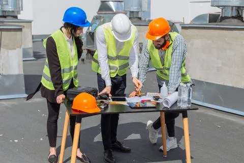 Multiethnic group of workers engineers architects foreman analyzing the plan of Stock Photos