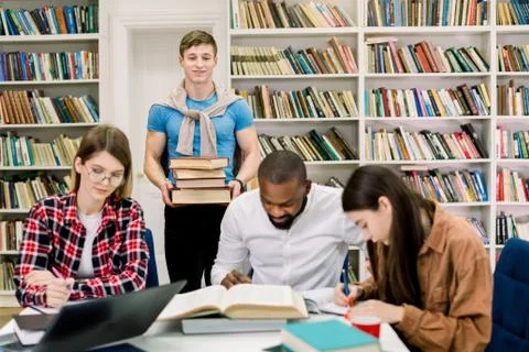 Multiethnic group of young people, students, studying together at the table,  Stock Photos