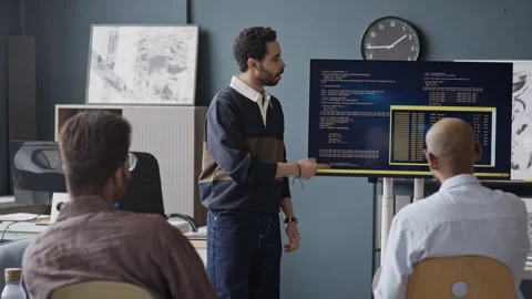 Multiethnic Male Developers Analyzing Code on Screen during Office Meeting Stock Footage 337479531