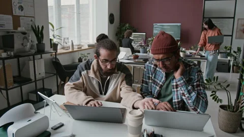 Multiethnic Male Programmers with Laptops Collaborating on Project in Office Video stock 285705215