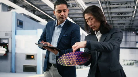 Multiethnic management executives use device to examine semiconductor substrate Stock Footage 333395011