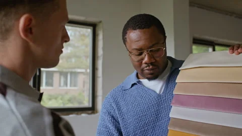 Multiethnic Men Selecting Upholstery Fabric Swatches for Renovation Stock Footage 340630326