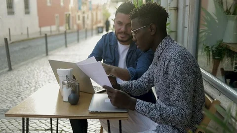 Multiethnic men working with papers and laptop in cafe Stock Footage 101366193