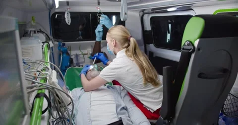 Multiethnic paramedics saving life of old man in ambulance. Medic giving oxygen Stock Footage 158309768