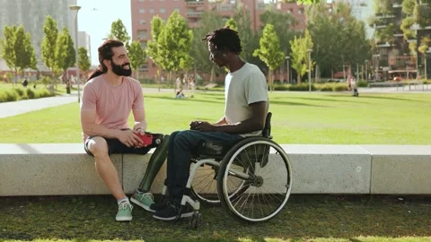 Multiethnic people with physical disability having fun sitting outdoor at park Stock Footage 197482656