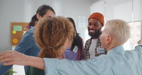 Multiethnic positive people hugging during therapy session in support meeting Stock Footage 154151085