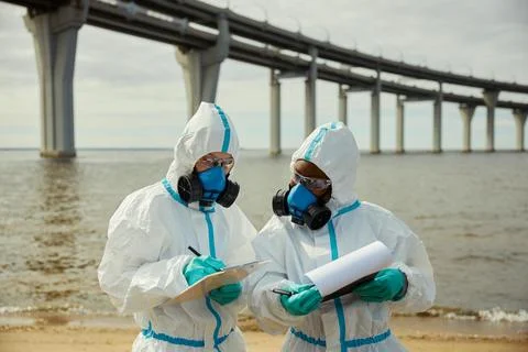 Multiethnic Scientists in Hazmat Suits Analyzing Water Pollution Stock Photos