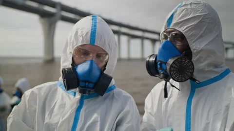 Multiethnic Scientists in Hazmat Suits Inspecting Ecological Disaster Stock Footage 344717051