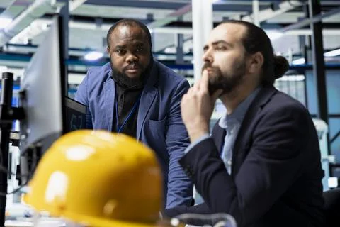 Multiethnic solar panel engineering team shares data insights in factory Stock Photos