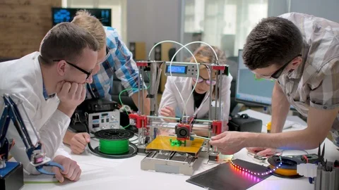 Multiethnic Students Discussing 3D Printed Mechanism in a New Modern Laboratory. Stock Footage 97620063