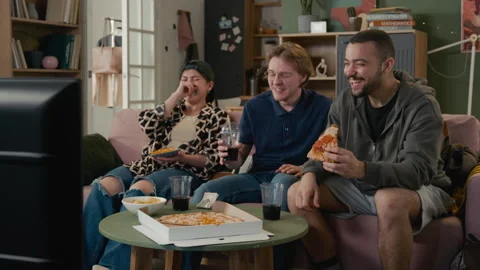 Multiethnic Students Eating Pizza Drinking Soda Watching TV at Home Stock Footage 336624182