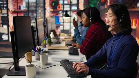 Multiethnic team of call center agents answering clients Stock Photos