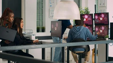 Multiethnic team of coders encountering system error message on computer 스톡 사진