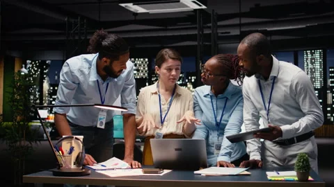 Multiethnic team collaborating in modern office workspace at night Stock Footage 334039950