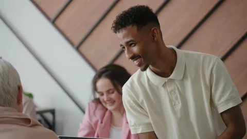 Multiethnic team discuss a project together sitting at a desk Video stock 235859755
