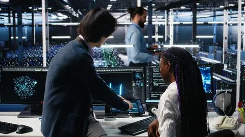 Multiethnic team in diverse data center coding with generative AI assistance Foto stock