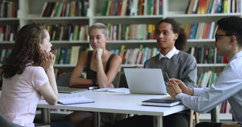 Multiethnic team of high school students talking in library Stock Footage 245260314