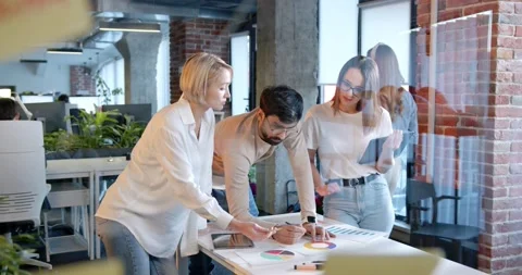 Multiethnic team of IT startup having conversation in coworking space and Stock Footage 180064248