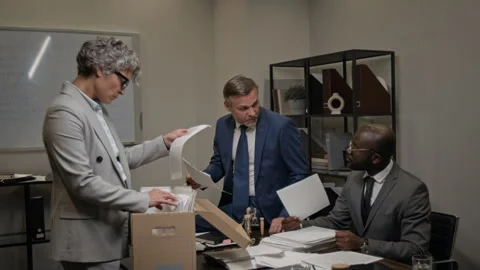 Multiethnic Team of Lawyers Searching through Document Archive in Office Stock Footage 323708041