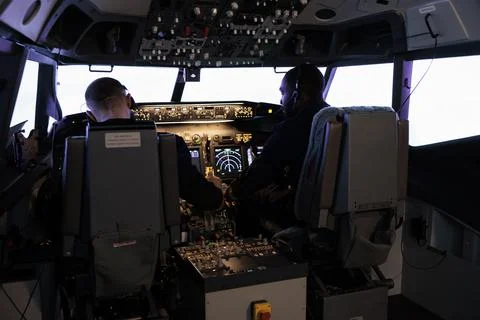 Multiethnic team of pilots using control command to fly plane Foto stock