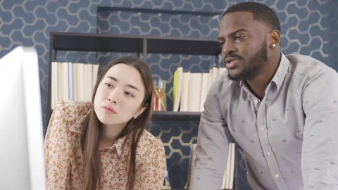 Multiethnic teamwork, african man and asian woman working in office. Stock Footage 228805611