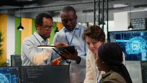 Multiethnic technicians use devices in AI startup to train predictive models Stock Footage 322708422