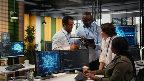 Multiethnic technicians use devices in AI startup to train predictive models 写真素材