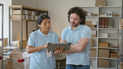 Multiethnic Warehouse Workers Checking Inventory on Digital Tablet Stock Footage 346053851