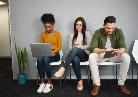 Multiethnic work applicants busy using laptops and smartphones preparing for Stock Photos