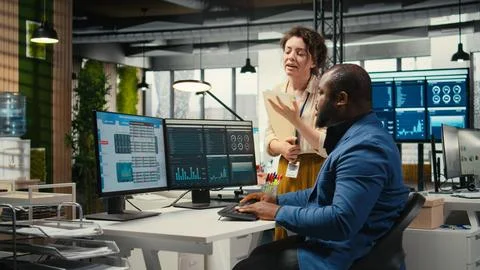 Multiethnic work team consulting each other in completing monthly reports Stock Photos