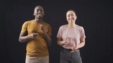Multiethnic young friends dancing on black background. 스톡 동영상 228847670