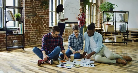 Multiethnical group of students brainstorming over their studing task on the Stock Footage 100994675