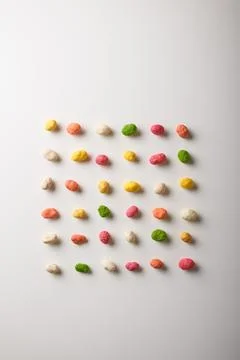 Multiflavored peanuts in bright multicolored icing on white table background Stock Photos
