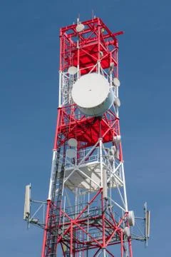 Multifunctional telecommunication tower - antennas on red and white pylon. Stock Photos