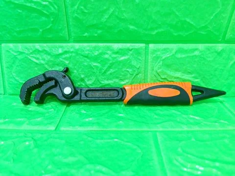 Multifunctional wrench on the green surface Stock Photos