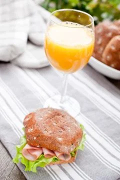 Multigrain bread roll with glass of orange juice on the table Foto stock