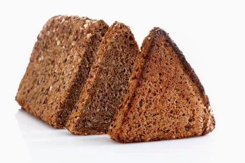 Multigrain rye bread loaf with slice on white background, close up Stock Photos