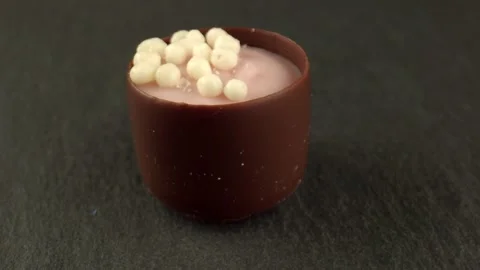 Multilayer candy with chocolate shell and various additives on the table. High Stock Footage 164632275