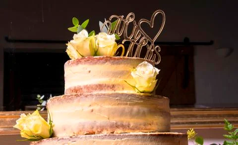 Multilayer wedding cake without edge with white roses and love plugs draped a Foto stock