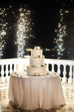 Multilevel wedding cake on the table decorated with roses Stock Photos
