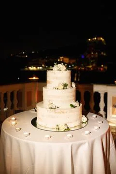 Multilevel wedding cake on the table decorated with roses Stock Photos