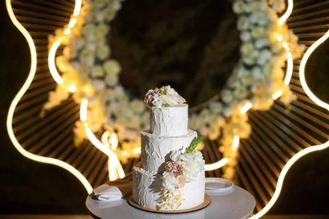 Multilevel wedding cake on the table decorated with roses Stock Photos