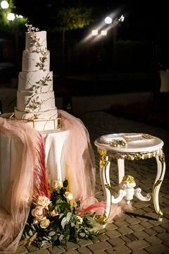 Multilevel wedding cake on the table decorated with flowers Stock Photos