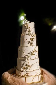 Multilevel wedding cake on the table decorated with flowers Stock Photos